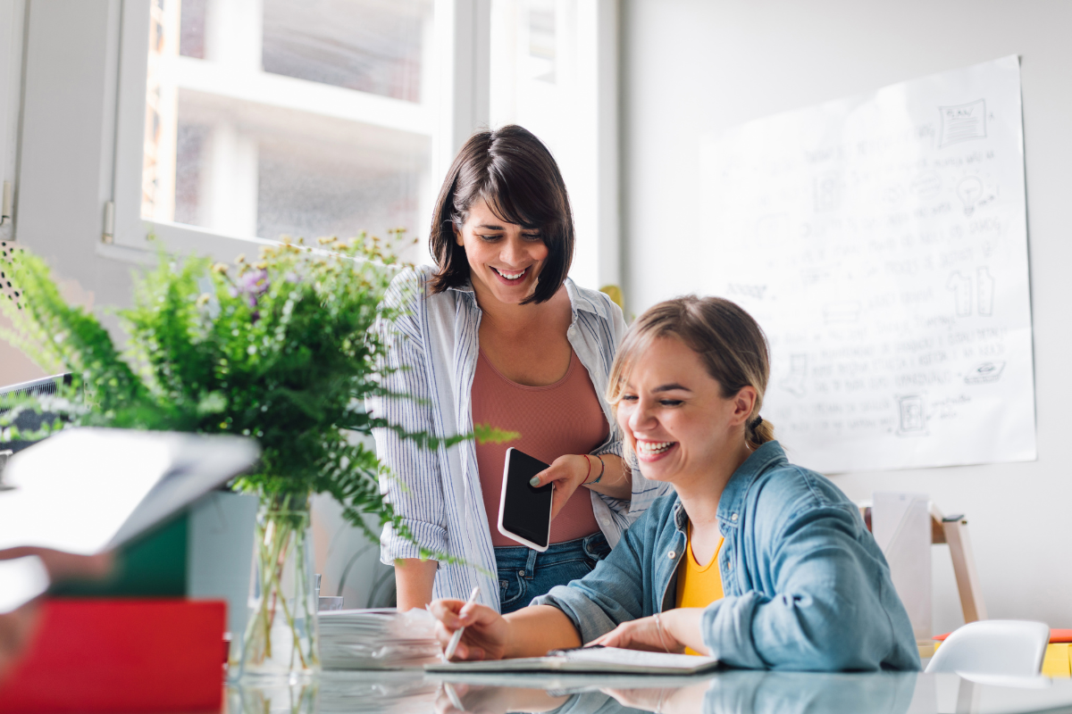 Deux gestionnaires de paie travaillant ensemble sur un ordinateur pour vérifier les bulletins de salaire et éviter les erreurs de paie courantes en 2026